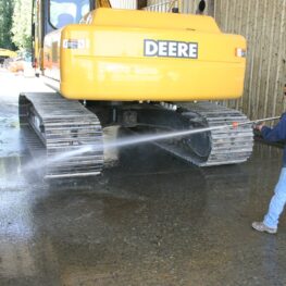 Man washing industrial equipment