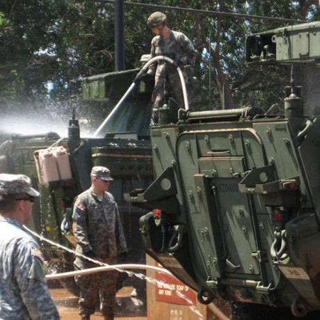 Military personnel washing vehicle